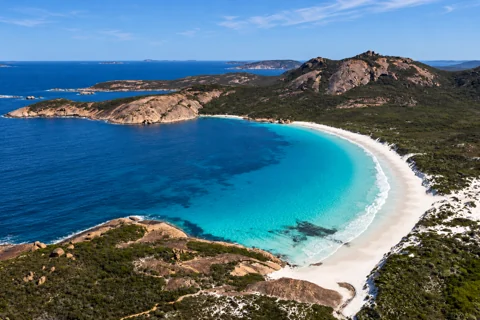 The white sand, granite headlands and turquoise water of Hellfire Bay
