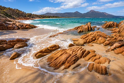 Granite rocks, sand and the mountain outlook at Hazards Beach in Freycinet National Park