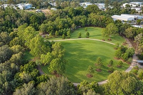 Rounded open lawn, surrounding path and trees at Rocks Riverside Park