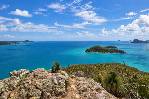 Rocky Passage Peak foreground above blue water and the actual surrounding Whitsunday islands