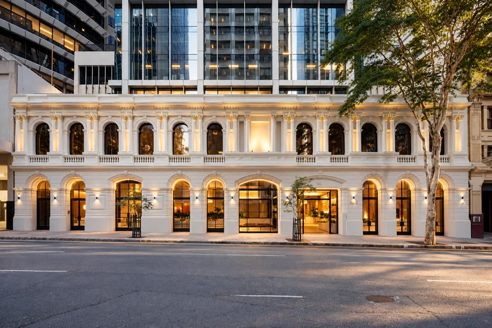 Cream arched heritage frontage beneath the glass offices of Midtown Centre in Brisbane