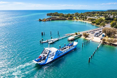 Blue-and-white SeaLink vehicle ferry beside the Dunwich terminal on North Stradbroke Island.